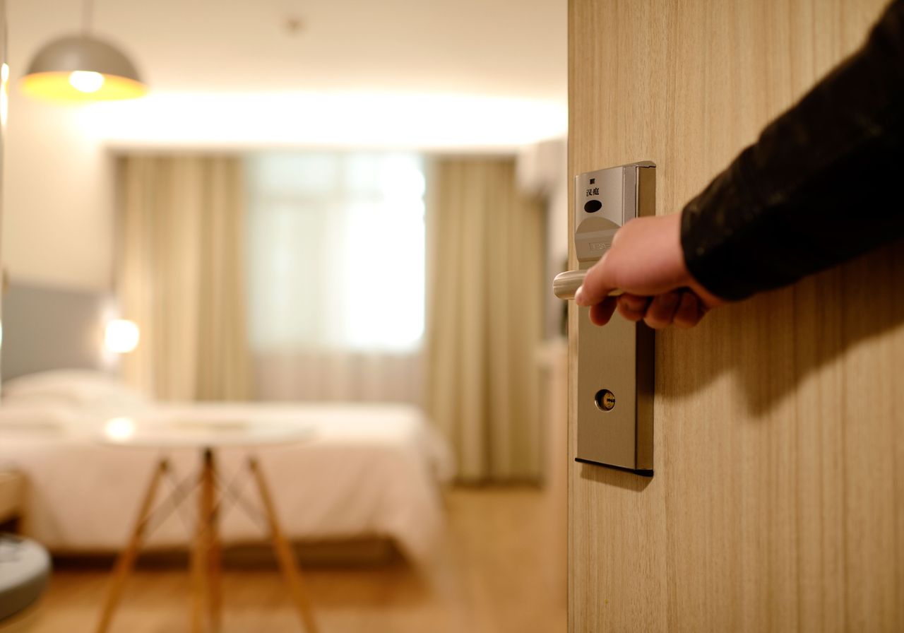 about-img A soft-lit hotel room entrance, welcoming guests with luxury appeal and comfort.