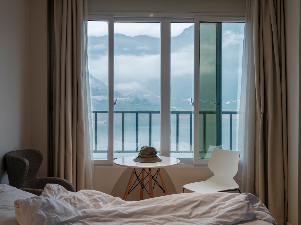 services-03 Cozy hotel room with mountain view through large window, perfect for relaxation.