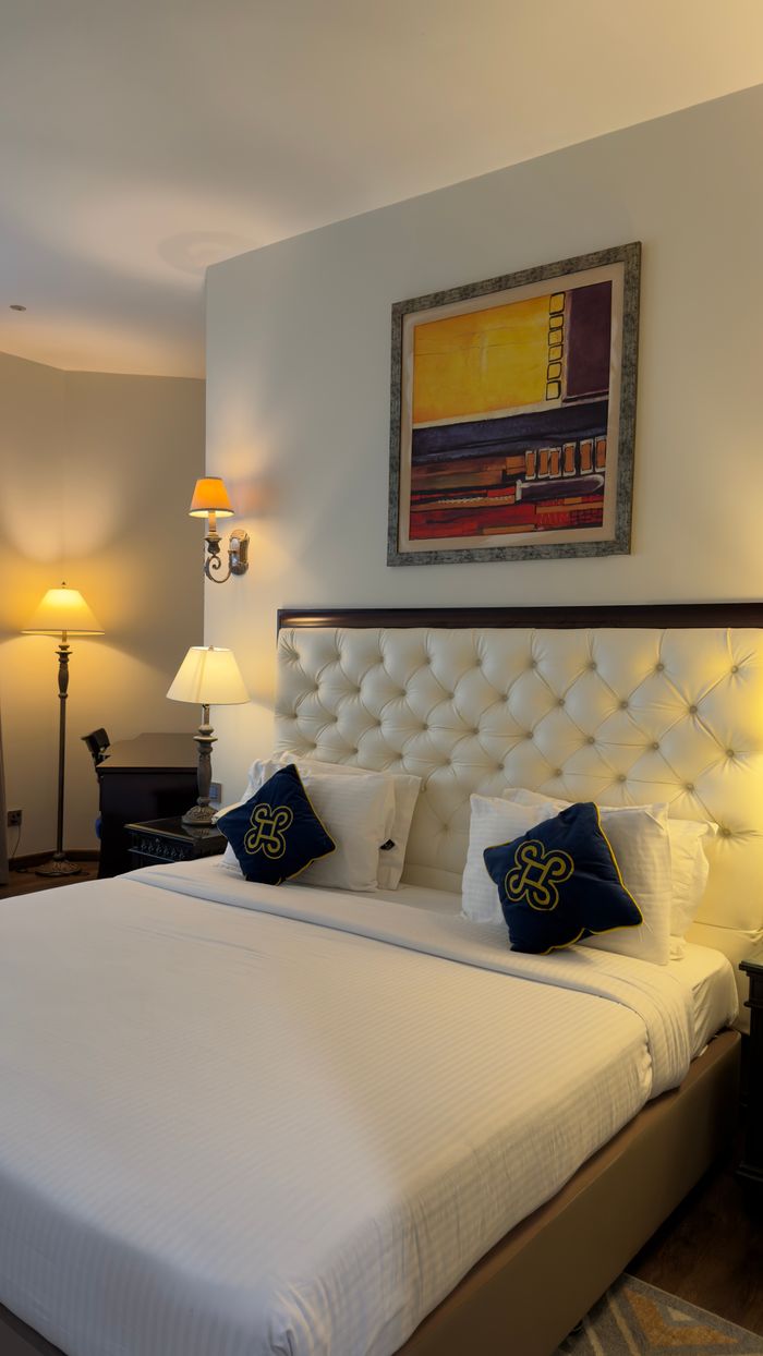 Mastering the First Impression: Your intriguing post title goes here Luxurious hotel room featuring a plush bed, decorative pillows, and modern lighting for a cozy stay.