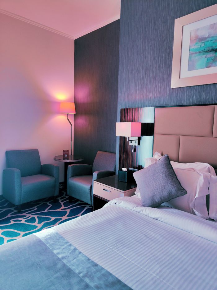 Crafting Captivating Headlines: Your awesome post title goes here Stylishly lit hotel room with chairs, bedside table, and modern decor. Perfect for travelers.